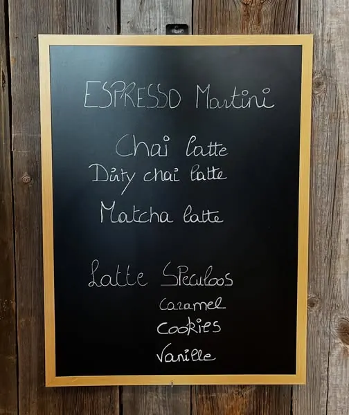 Krijtbord met chai latte, matcha latte en latte speculoos